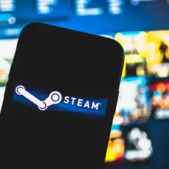 Telefon z logo Steam na tle ekranu z grami.